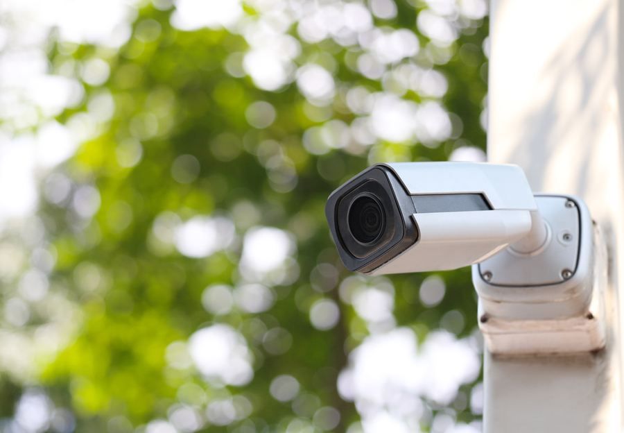 a security camera with a white casing installed outside a home.