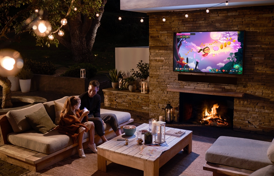 Samsung Terrace TV mounted above an outdoor fireplace.